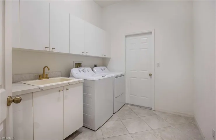 Laundry room featuring cabinet space, washing machine and clothes dryer, and light tile patterned flooring