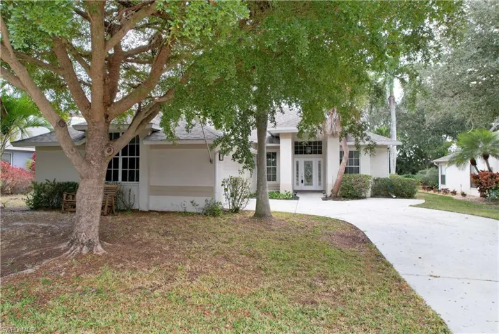View of front of home featuring stucco siding, french doors, a shingled roof, a front yard, and concrete driveway