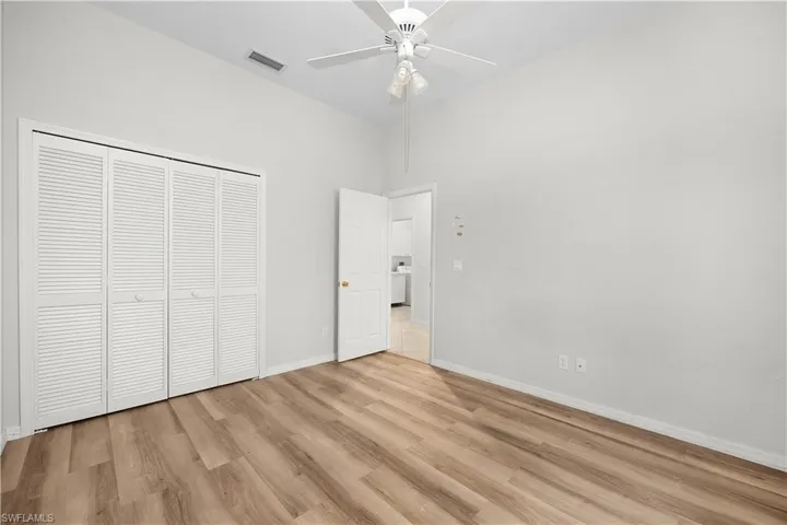 Unfurnished bedroom with light wood-style floors, a closet, and a ceiling fan