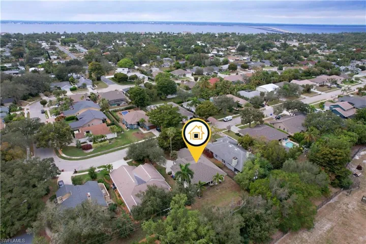 Aerial overview of property's location with nearby suburban area and a nearby body of water
