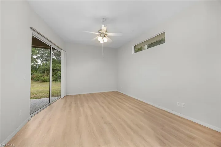 Spare room with light wood-type flooring, healthy amount of natural light, and ceiling fan
