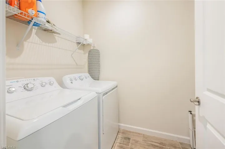 Laundry room with washer and clothes dryer and baseboards