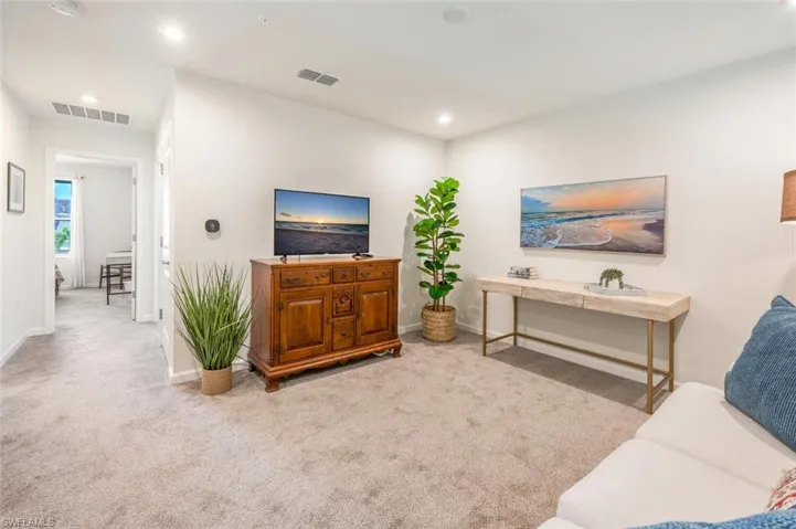 Carpeted living area featuring baseboards and recessed lighting
