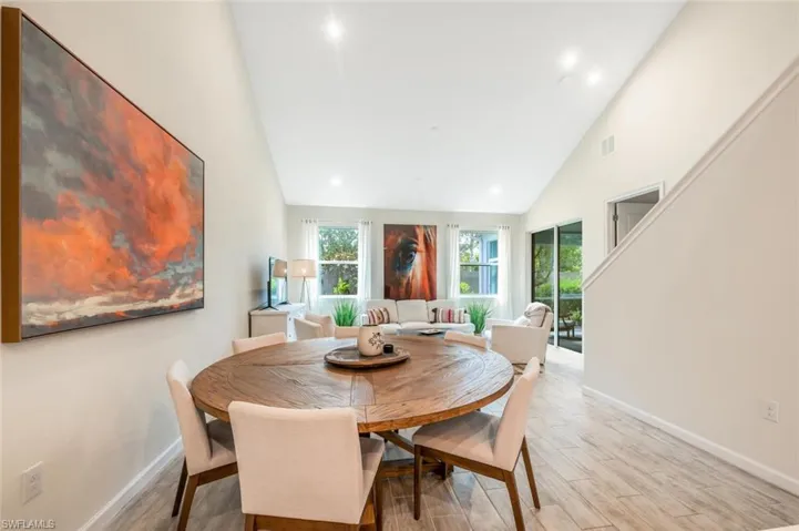 Dining room featuring healthy amount of natural light, high vaulted ceiling, light wood-style floors, and recessed lighting