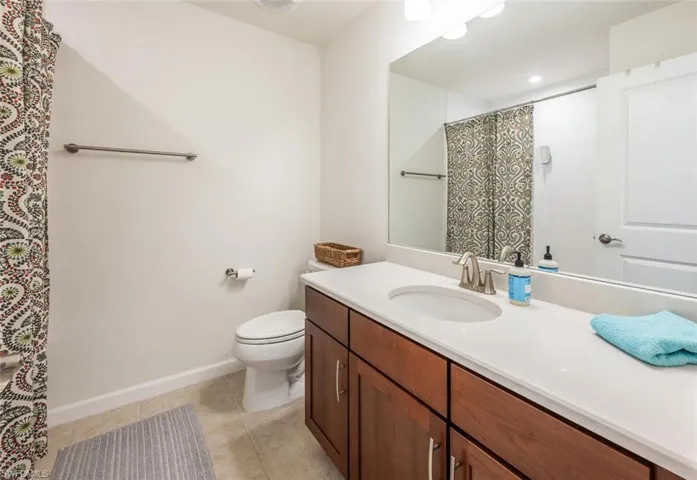 Bathroom featuring vanity, tile patterned floors, and a shower with curtain