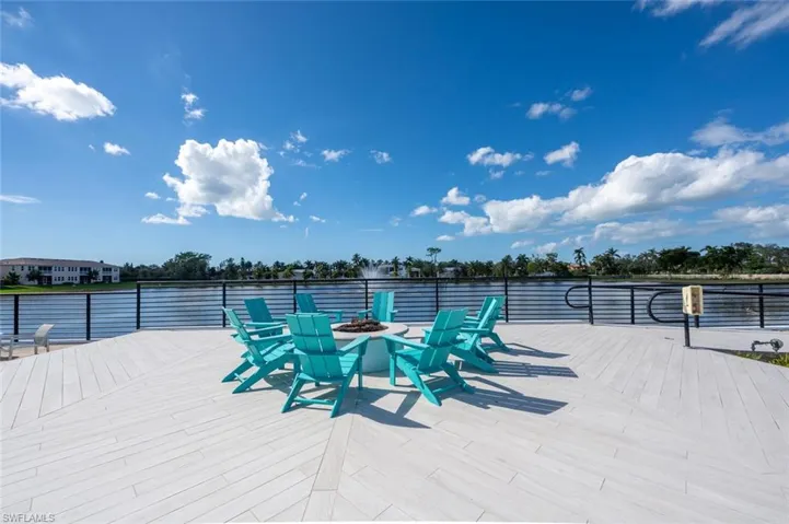 Wooden deck featuring a fire pit and a water view