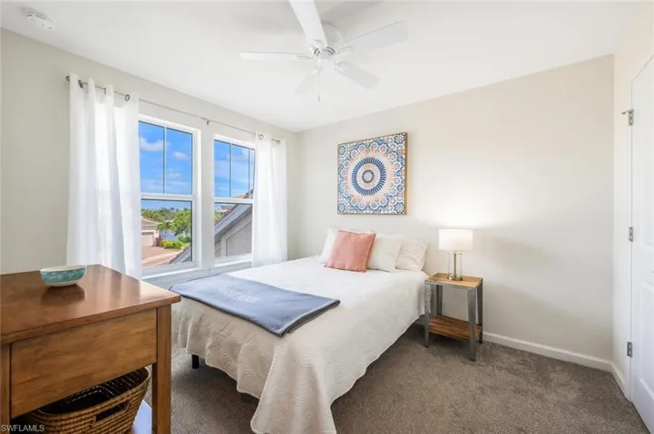 Carpeted bedroom featuring baseboards and a ceiling fan