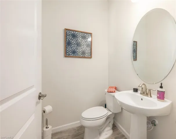Half bath featuring wood finished floors and toilet