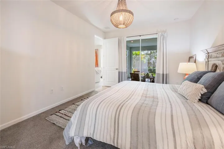 Bedroom featuring a chandelier, access to exterior, and carpet flooring