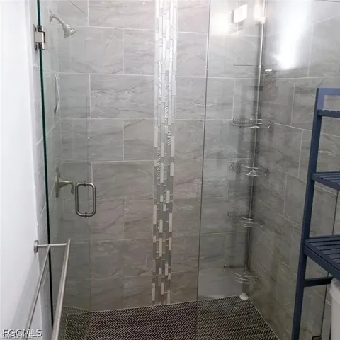 Walk-in shower with clear glass enclosure and brushed nickel fixtures