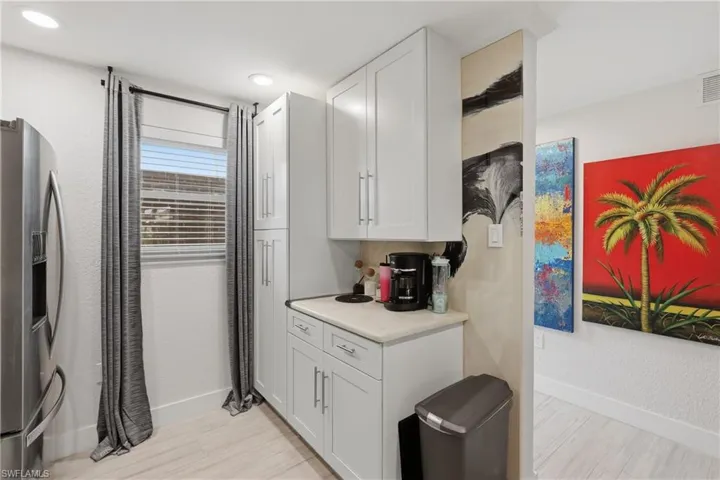 Kitchenette featuring white shaker-style cabinetry, a light-toned countertop, and recessed lighting