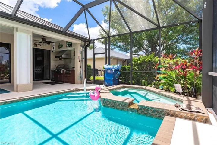 View of pool featuring glass enclosure, an in ground hot tub, and ceiling fan