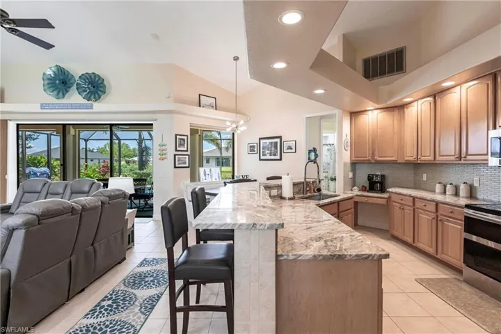 Kitchen featuring ceiling fan, decorative light fixtures, backsplash, sink, and appliances with stainless steel finishes