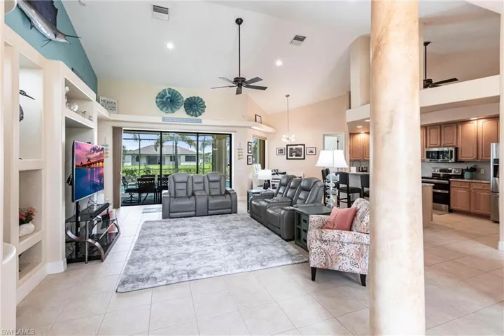 Living room featuring built in features, ceiling fan, and light tile flooring