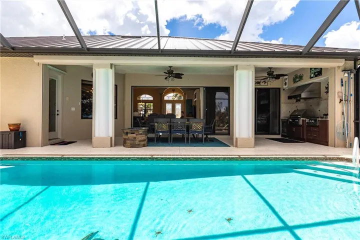 View of pool featuring outdoor lounge area, a lanai, a patio area, and ceiling fan