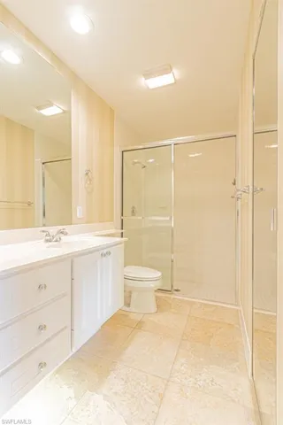 Full bath featuring vanity, a stall shower, light tile patterned floors, recessed lighting