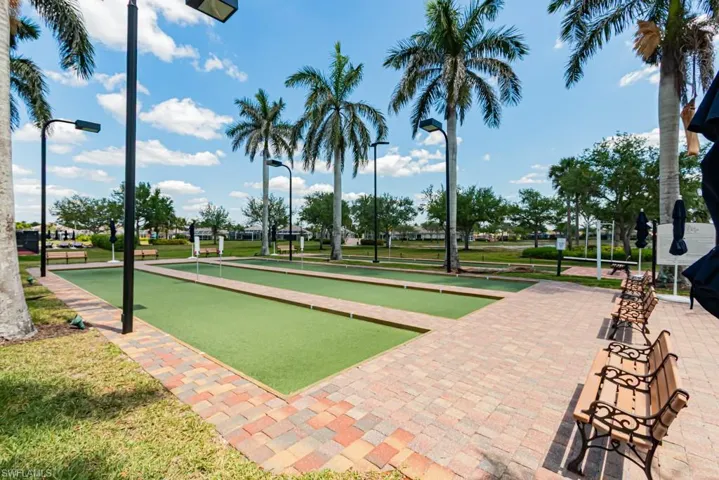 View of community with a bocce ball area and a yard