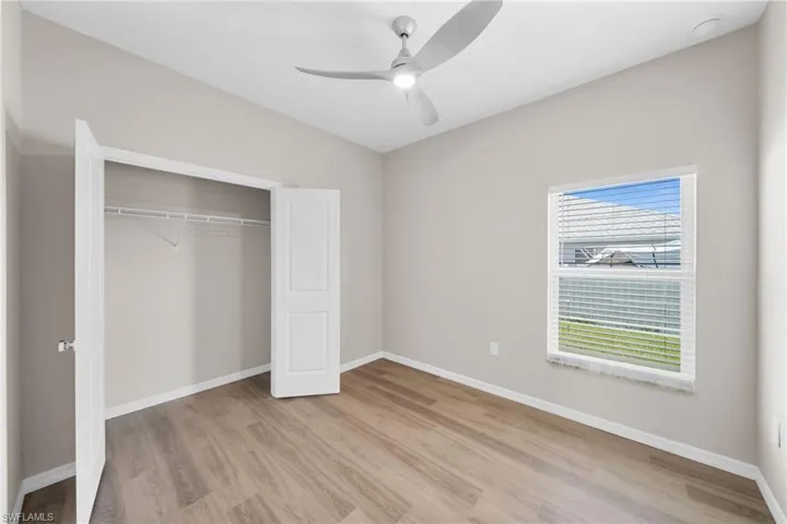 Unfurnished bedroom featuring ceiling fan, light wood-type flooring, and a closet