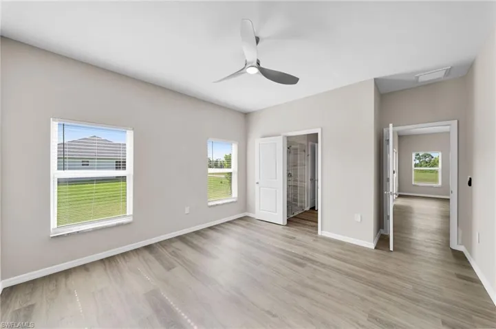 Unfurnished bedroom featuring light hardwood / wood-style flooring, multiple windows, and ceiling fan