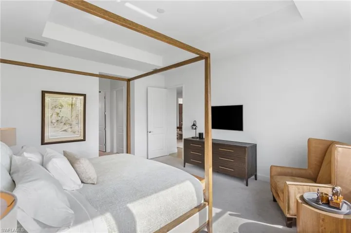 Bedroom featuring carpet flooring and a raised ceiling