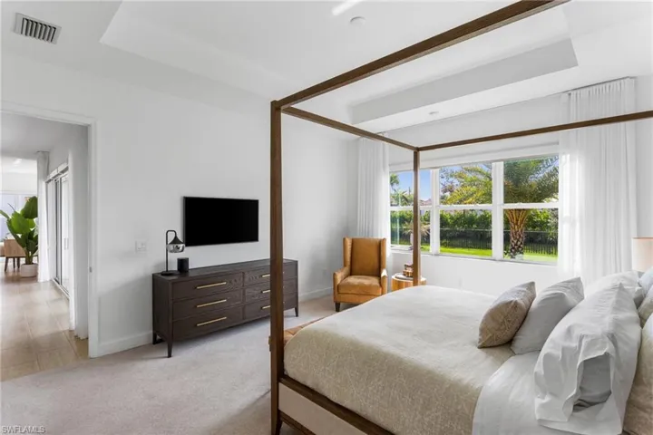 Bedroom with light colored carpet and baseboards