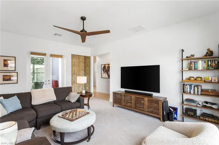 Carpeted living room featuring a ceiling fan