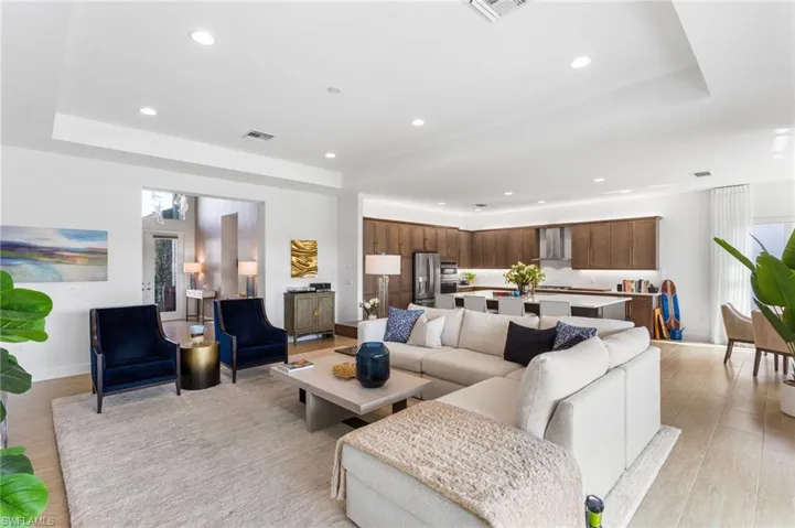 Living room featuring recessed lighting, a raised ceiling, and light wood-type flooring