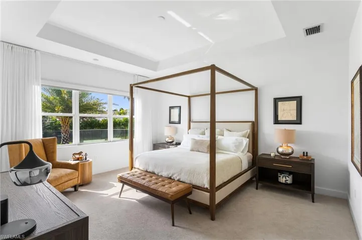 Carpeted bedroom featuring a raised ceiling