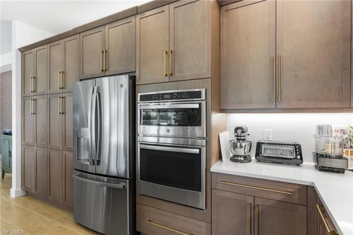 Kitchen featuring appliances with stainless steel finishes and light stone counters