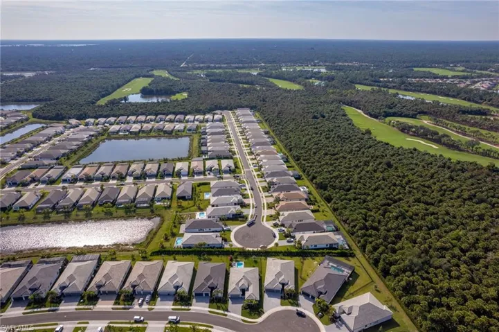 Aerial view of property and surrounding area with nearby suburban area and a nearby body of water