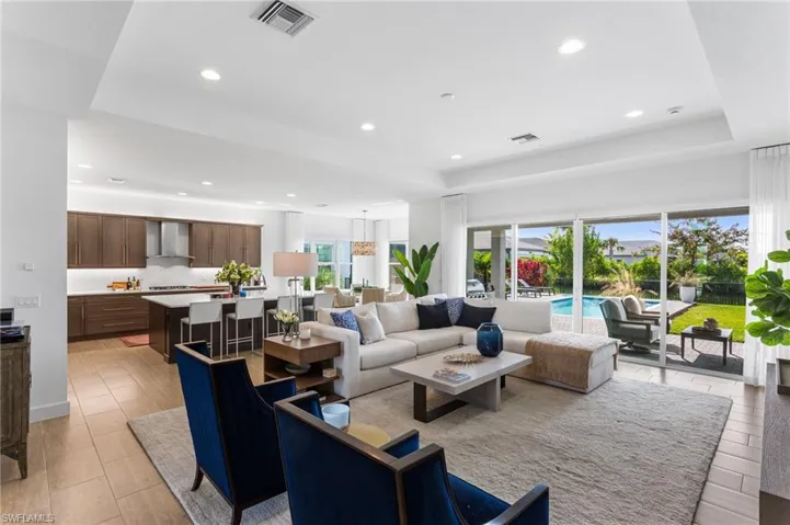 Living area with recessed lighting and a raised ceiling