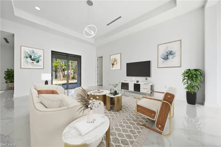 Spacious living area featuring high ceilings, large format tile flooring, a contemporary pendant light fixture, and sliding glass doors