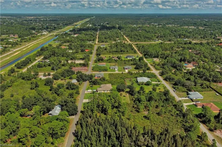 Aerial overview of property's location with a large body of water and a heavily wooded area