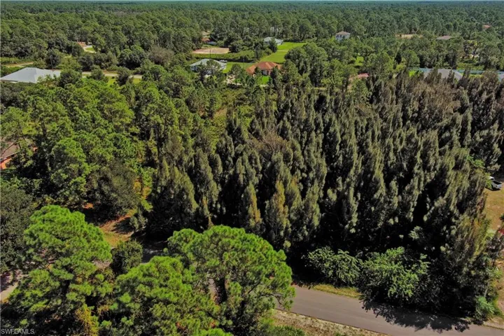 Aerial view of property's location with a heavily wooded area
