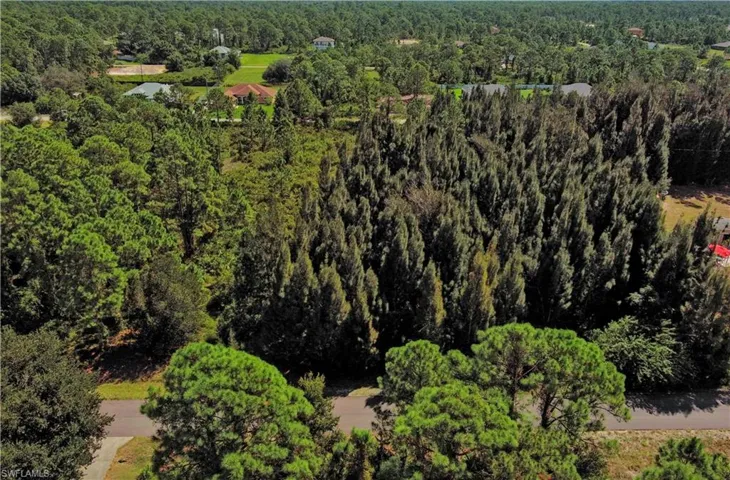 Aerial view of property and surrounding area featuring a heavily wooded area