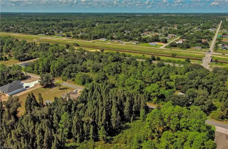 Aerial overview of property's location with a heavily wooded area