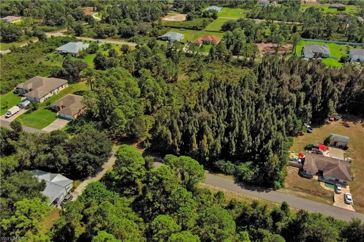View of property location with nearby suburban area and a tree filled landscape