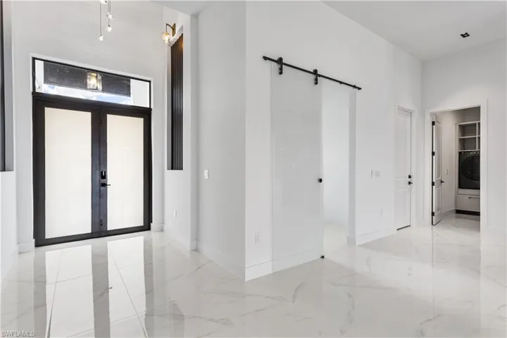 FOYER invites you to admire the BLUE PANELING & lamps & CHANDELIER.
