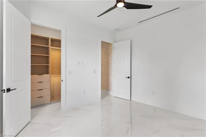Guest Bedroom 3 with walk-in closet with custom built lighted cabinets
