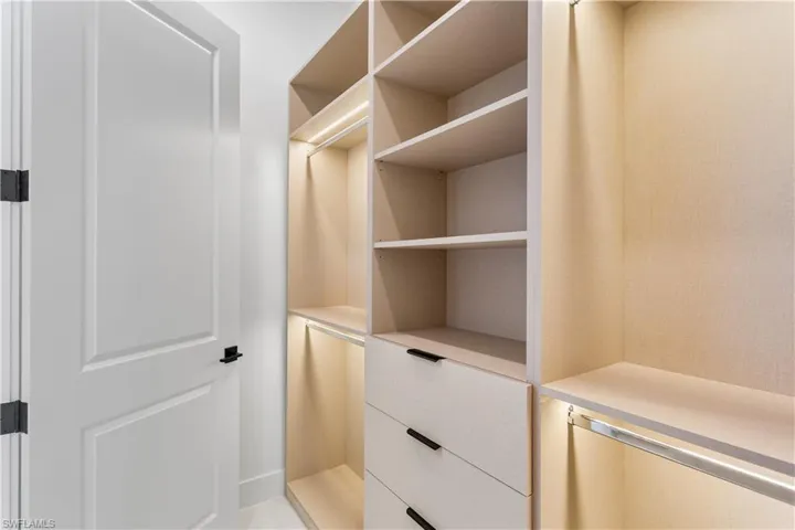 HIS and HER WALK-IN CLOSETS w/ custom built lighted cabinetry.