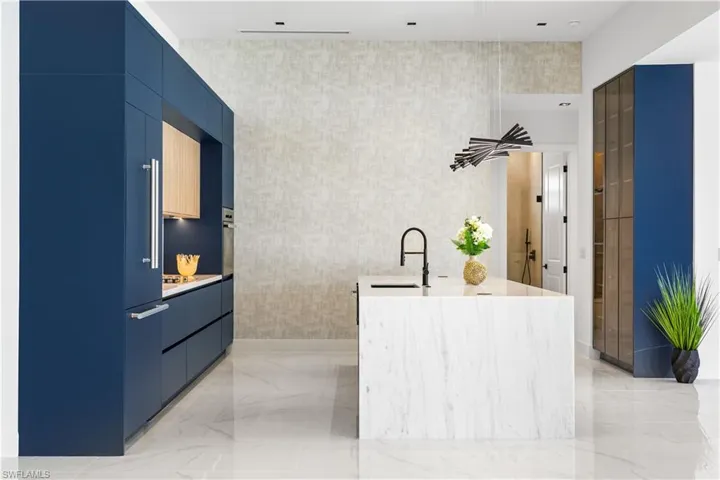 LARGE SINK w/ sleek black faucet & WATERFALL kitchen ISLAND w/ STORAGE & SEATING AREA complements the kitchen's high-end finishes!