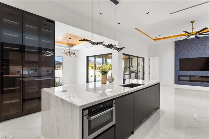Custom GLASS-DOORED PANTRY & STORAGE CABINETS enhance the elegance of this STUNNING KITCHEN, providing EXTRA SPACE for STORAGE & ORGANIZATION.