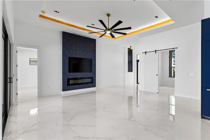 ELECTRIC FIREPLACE sets the mood, while 75-inch TV takes CENTER STAGE on BLUE & GOLD FEATURED WALL, perfect for ENTERTAINMENT & UNWIDING.