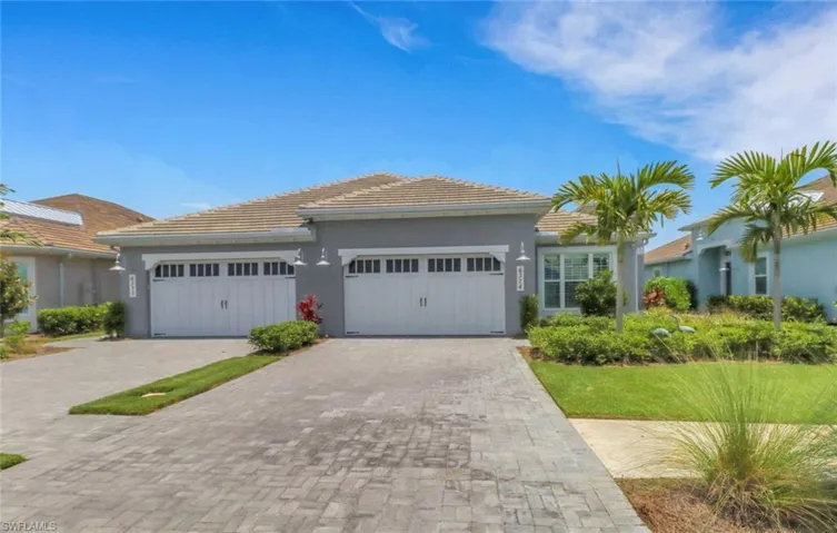 Single story home featuring an attached garage, decorative paver driveway, stucco siding, and a tiled roof