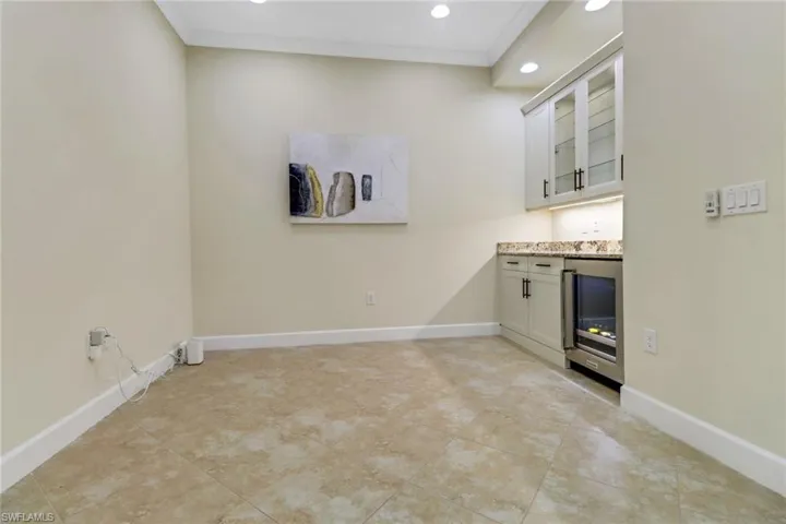 Indoor dry bar featuring wine cooler, recessed lighting, and light tile patterned floors