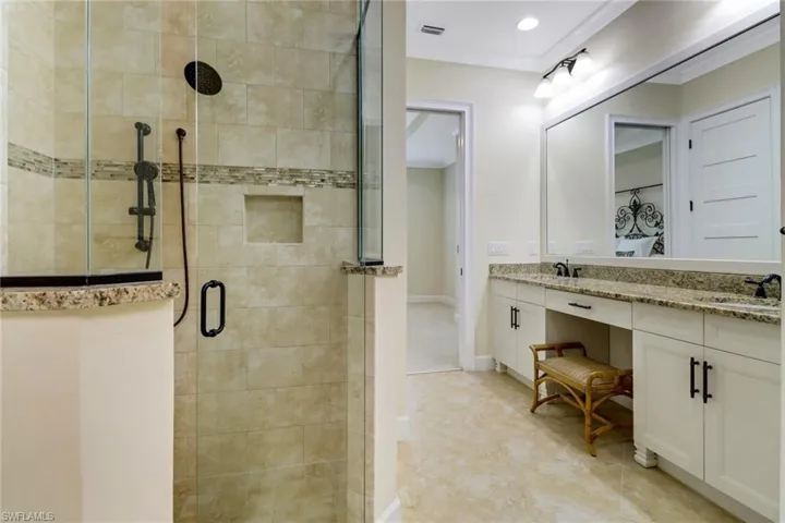 Full bathroom featuring a shower stall, double vanity, and recessed lighting