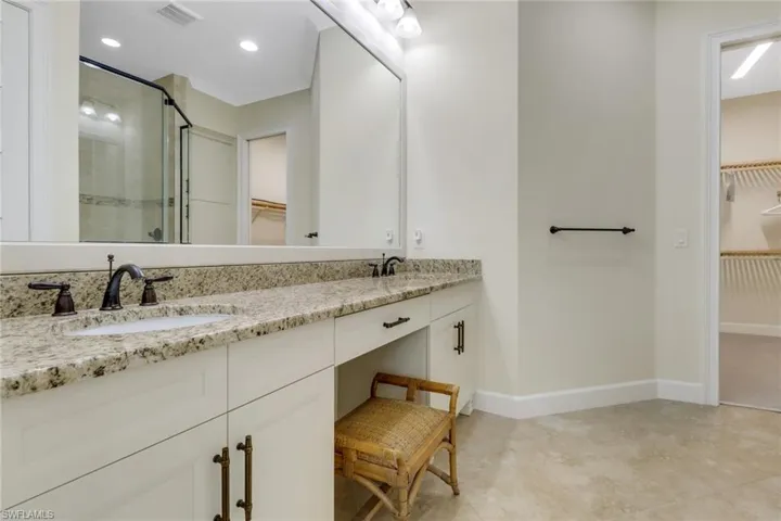 Bathroom featuring a spacious closet, a shower stall, double vanity, and recessed lighting