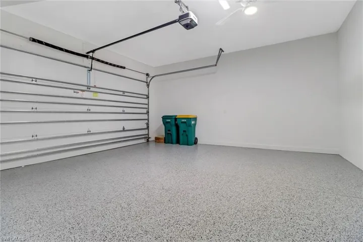 Garage featuring a garage door opener and baseboards