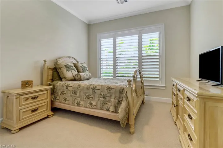 Bedroom featuring light carpet and ornamental molding