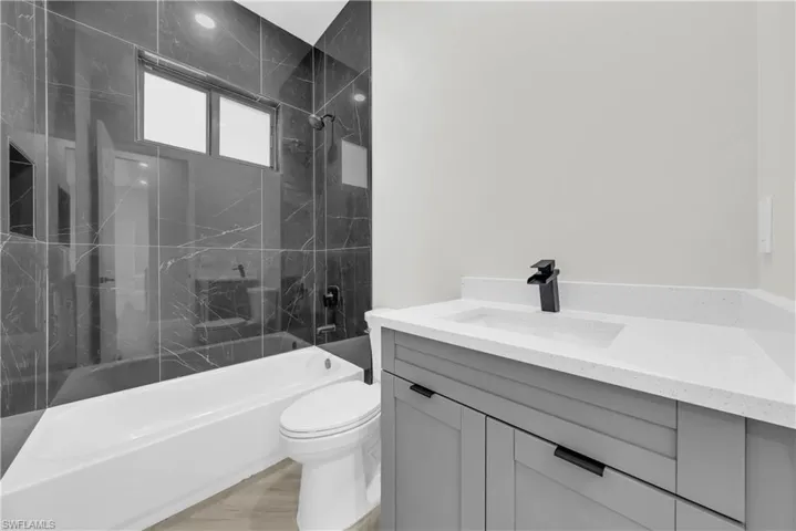 Bathroom with a combined bath / shower with marble appearance and vanity